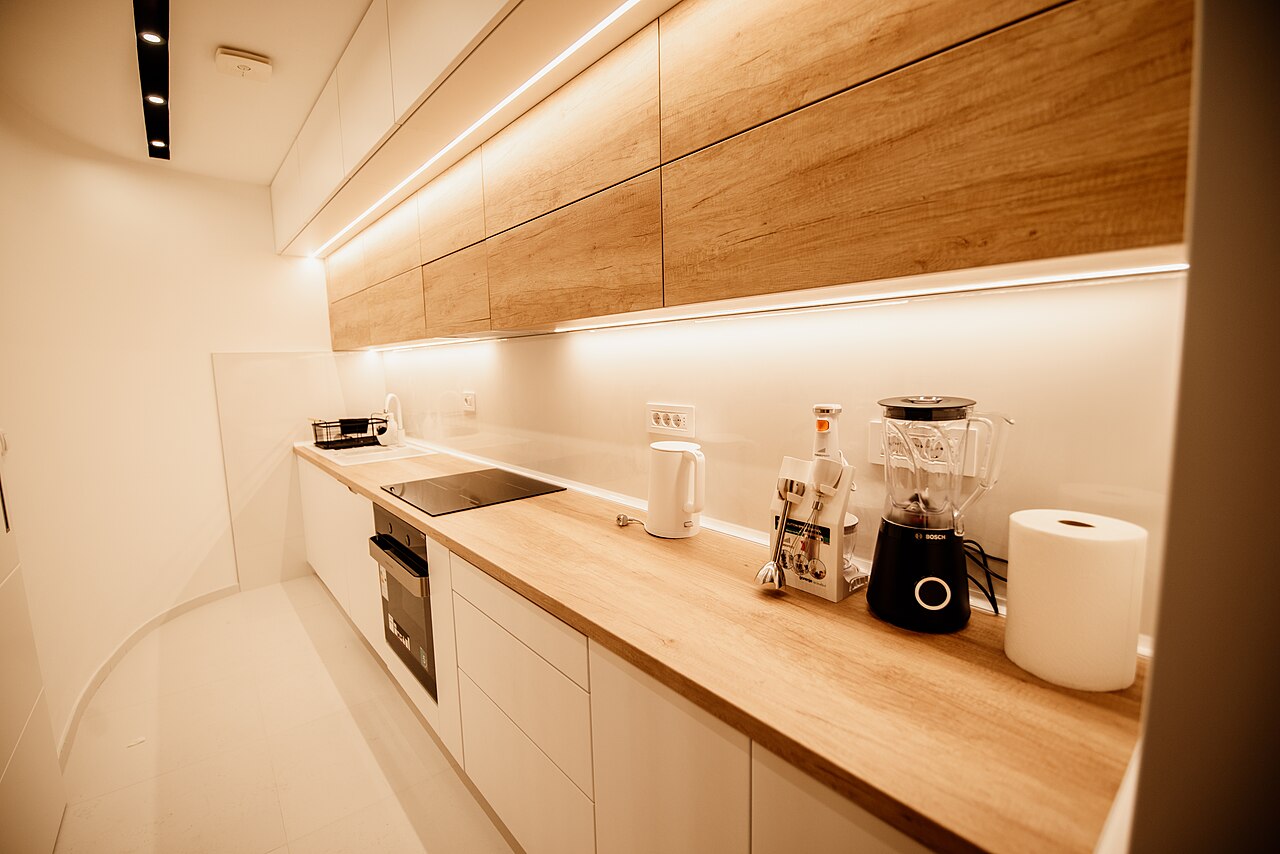 Cocina lineal de frentes blancos con encimera de madera